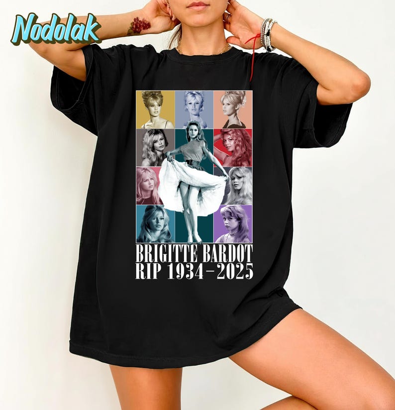 K&ouml;nnte beinhalten: Schwarzes T-Shirt mit einer farbenfrohen Collage von Brigitte Bardot-Bildern. Das Design enth&auml;lt ein zentrales Bild von Bardot in einem wei&szlig;en Kleid, umgeben von anderen Portr&auml;ts. Der Text lautet "BRIGITTE BARDOT RIP 1934-2025".