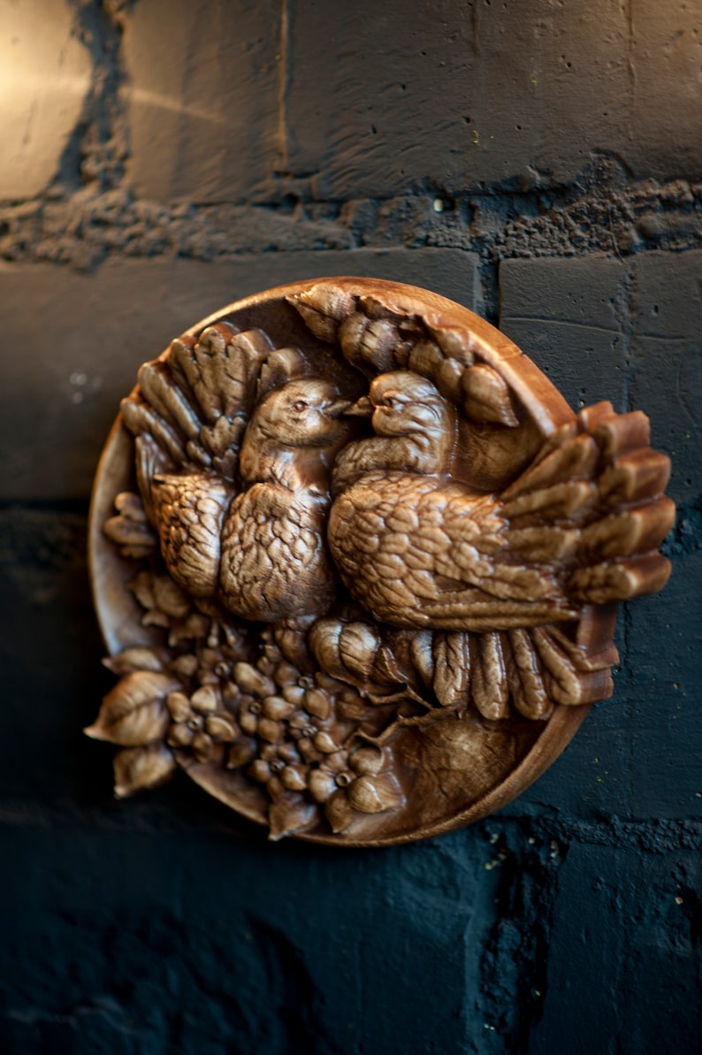 Round carved panel depicting doves