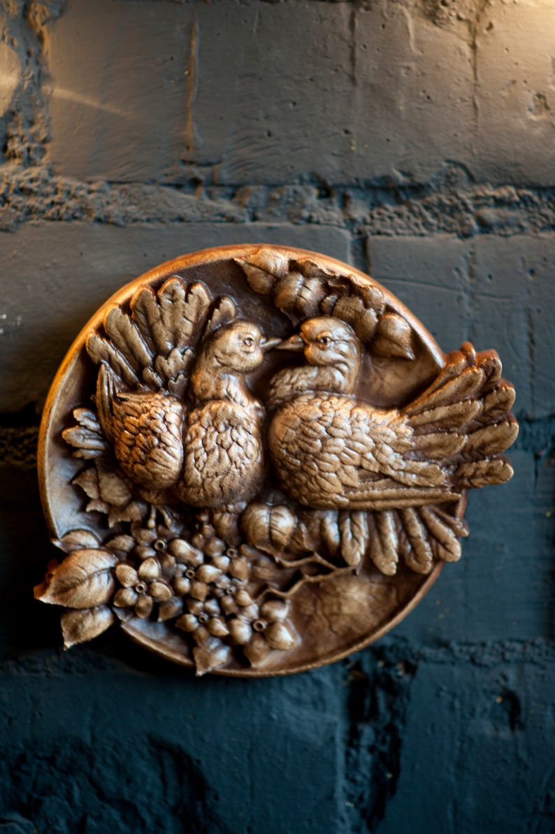 Round carved panel depicting doves