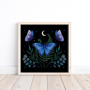 Puede incluir: Una impresión enmarcada de una mariposa azul con follaje verde y una luna creciente sobre un fondo negro. La mariposa está rodeada de pequeñas estrellas blancas.