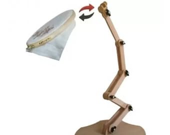 May include: A wooden embroidery hoop stand with a rotating arm. The stand has a wide base and a zig-zag design. The hoop is not attached to the stand.