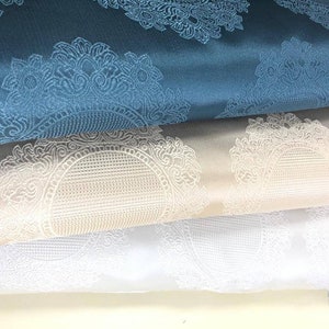 May include: Three fabric swatches with a white damask pattern. The top swatch is teal blue, the middle swatch is beige, and the bottom swatch is white.