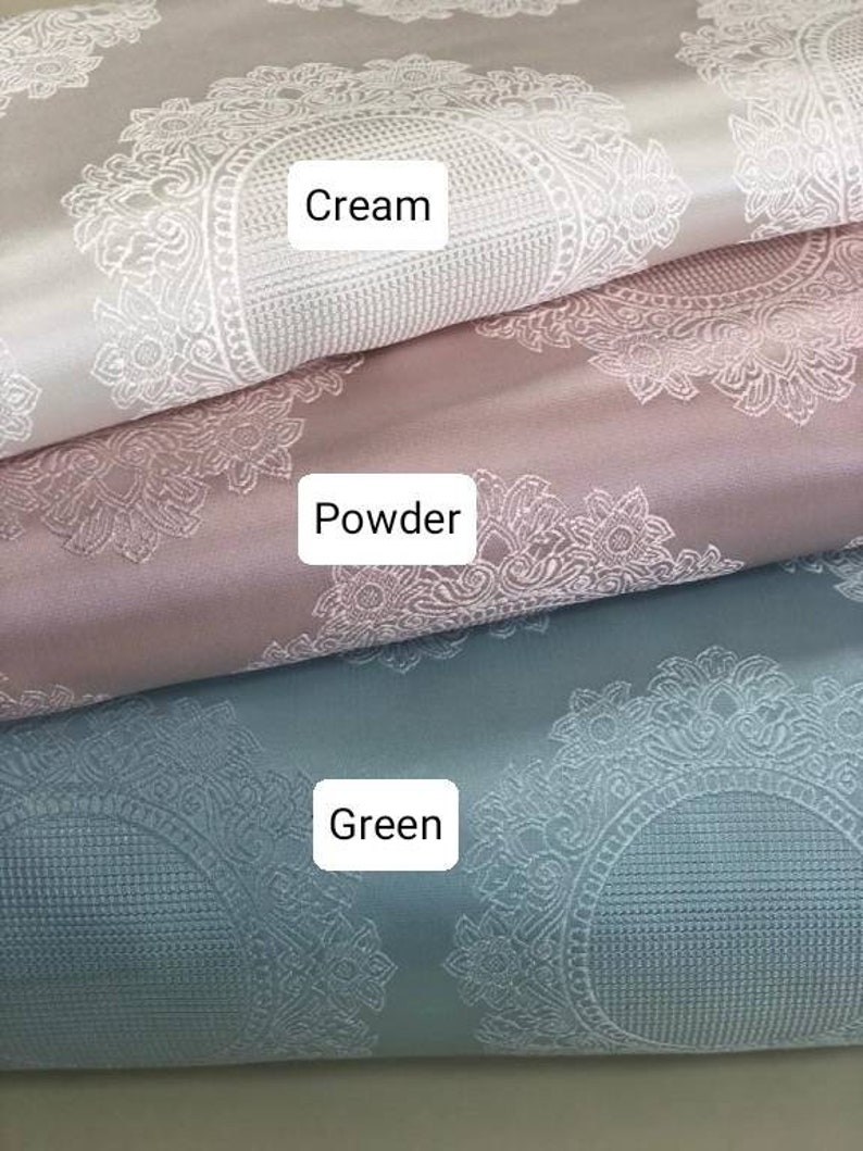 May include: Three fabric swatches with a white damask pattern. The top swatch is cream, the middle swatch is powder pink, and the bottom swatch is green.