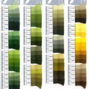 Peut inclure: Nuancier de fils &agrave; broder DMC avec 10 colonnes de couleurs de fils. Le nuancier comprend des nuances de vert, jaune, marron et beige. Chaque colonne est &eacute;tiquet&eacute;e avec un num&eacute;ro et un num&eacute;ro de fil DMC.