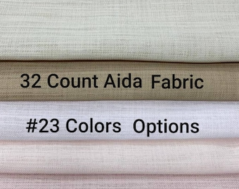Può includere: Primo piano di una pila di tessuto Aida di diversi colori. Lo strato superiore è di colore beige chiaro, il secondo strato è di colore marrone chiaro, il terzo strato è bianco, il quarto strato è di colore rosa chiaro e lo strato inferiore è di colore marrone chiaro. Il testo "32 Count Aida Fabric" è stampato sul secondo strato e il testo "#23 Colors Options" è stampato sul terzo strato.