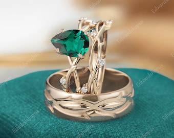 May include: A rose gold engagement ring set with a pear-shaped emerald green gemstone and smaller diamonds set in a delicate vine design.