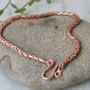 May include: A rose gold snake chain bracelet with a lobster clasp closure.