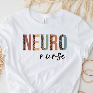 May include: White t-shirt with the text "NEURO nurse" in colorful letters with a leopard print pattern.