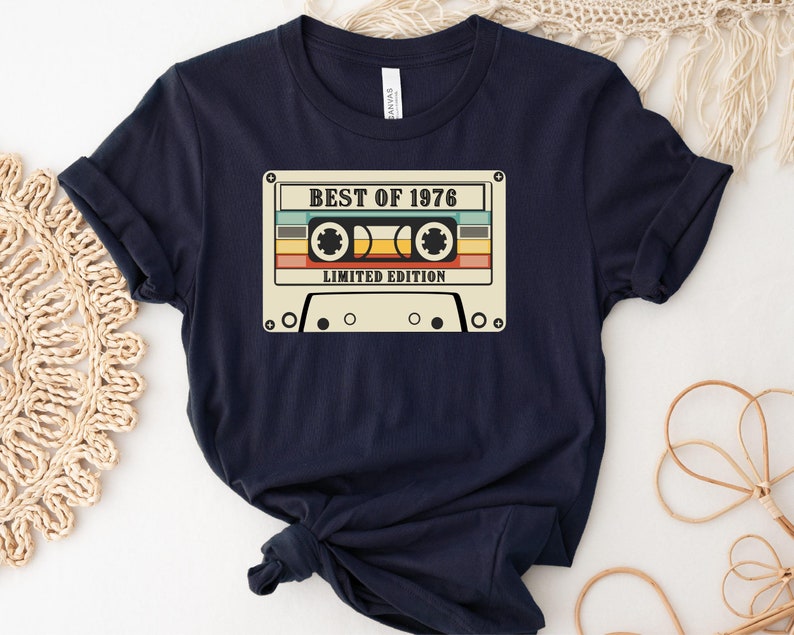 May include: A navy blue t-shirt with a vintage cassette tape graphic. The tape has the text "BEST OF 1976" and "LIMITED EDITION".