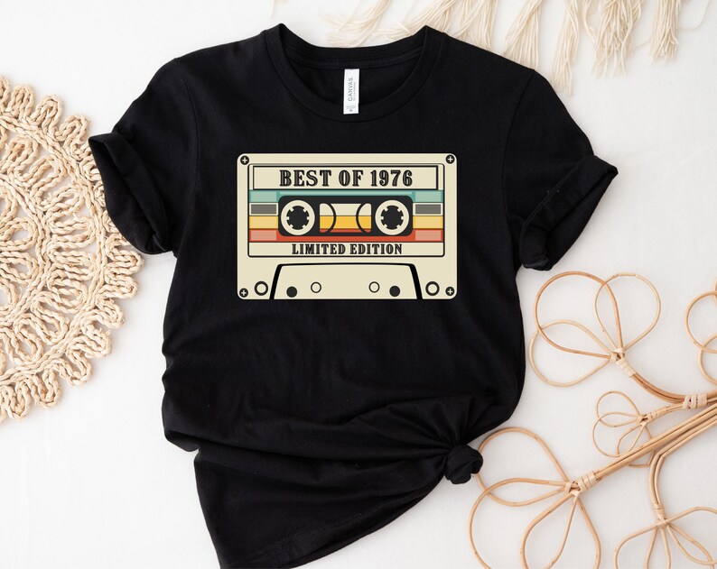May include: Black t-shirt with a vintage cassette tape graphic that says "Best of 1976 Limited Edition".