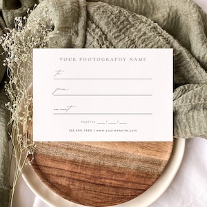 May include: A white gift certificate for photography services. The certificate has blank lines for the recipient's name, the sender's name, and the amount. It also has a line for the expiration date and contact information for the photography business.