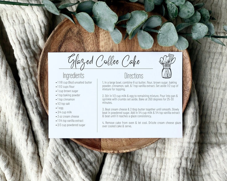 K&ouml;nnte beinhalten: Eine wei&szlig;e Rezeptkarte mit dem Titel "Glazed Coffee Cake" in schwarzer Schrift. Die Karte listet die Zutaten und Anweisungen f&uuml;r die Zubereitung des Kuchens auf. Die Zutaten umfassen 1 1/8 Tasse (9oz) ungesalzene Butter, 1 1/2 Tassen Mehl, 1 Tasse braunen Zucker, 1 TL Backpulver, 1 TL Zimt, 1/2 TL Salz, 1 Ei, 3/4 Tasse Milch, 3 oz Frischk&auml;se, 1 1/4 TL Vanilleextrakt und 2/3 Tasse Puderzucker. Die Anweisungen umfassen das Vermischen der Zutaten, das Backen des Kuchens bei 175 Grad Celsius f&uuml;r 25-30 Minuten und die Herstellung eines Frischk&auml;se-Glasurs.