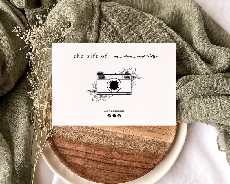 May include: A white card with black text that reads "the gift of memories" and a black and white illustration of a vintage camera with flowers. The text "@yoursocial" is below the camera with icons for Instagram, Facebook, and Twitter.