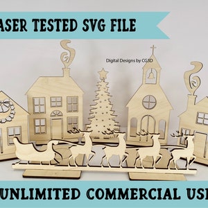 May include: Laser cut wooden Christmas village scene with a church, houses, a Christmas tree, and reindeer pulling a sleigh. The text "LASER TESTED SVG FILE" and "UNLIMITED COMMERCIAL USE" is visible on the image.
