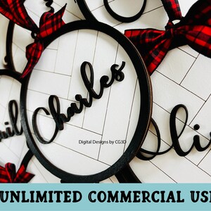 May include: Black wooden name signs with a circular frame and red and black plaid ribbon bows. The names "Emil", "Charles", and "Olivia" are displayed in a cursive font against a white background with a diagonal pattern. The text "UNLIMITED COMMERCIAL USE" is at the bottom.
