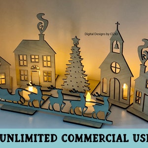 May include: A wooden Christmas village scene with a church, houses, a Christmas tree, and a sleigh with reindeer. The houses and church have windows and doors, and the tree is decorated with stars. The scene is lit with tea lights.