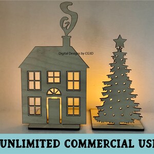 May include: A wooden cutout of a house with a chimney and a star-topped Christmas tree. The house has windows and a door. The tree has a star on top and is decorated with circles. The text "Digital Designs by CG3D" is visible on the house. The text "UNLIMITED COMMERCIAL USE" is visible at the bottom of the image.