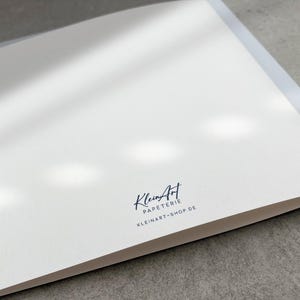 May include: A white card with a black logo that says "KleinArt Papeterie" and "kleinart-shop.de" in a handwritten font.