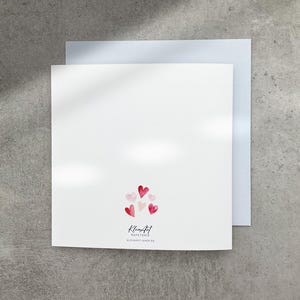May include: Blank white card with a pink and red heart design on the back. The card reads "Kleinfeld Papeterie" and "Old Hart - 10002-00".