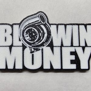 May include: Black and white keychain with the text "BLOWIN' MONEY" and a turbocharger graphic. The keychain has a silver key ring attached. The design is on a white background.