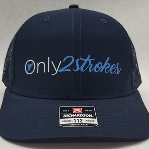 May include: A navy blue trucker hat with a black mesh back. The hat has white embroidery that says "Only2Strokes" in a cursive font. The text "Only" is in white and the text "2Strokes" is in light blue. The hat has a black and white label on the back that says "Richardson" and "Original 112 Trucker Adjustable".