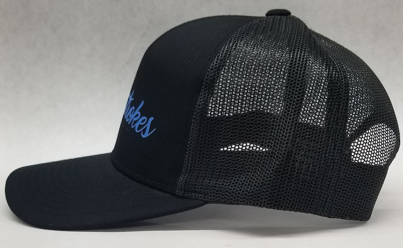 May include: Black trucker hat with a blue embroidered logo that says "Stokes".