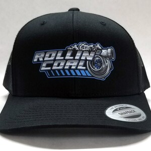 May include: Black trucker hat with a black mesh back. The hat has a silver and blue logo that says "Rollin' Coal" with a stylized image of a turbocharger.