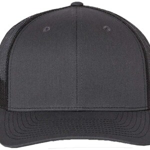 May include: A black trucker hat with a mesh back. The hat has a curved brim and a structured crown.