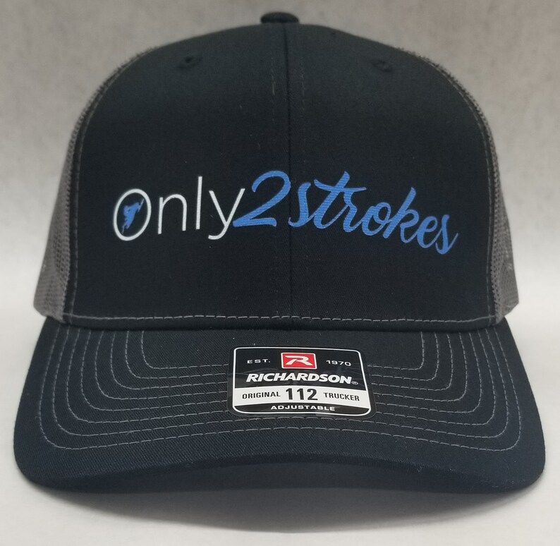 May include: Black and gray trucker hat with a white and blue embroidered logo that says "Only 2 Strokes". The hat has a Richardson label with the text "Est. 1970 Original 112 Trucker Adjustable".