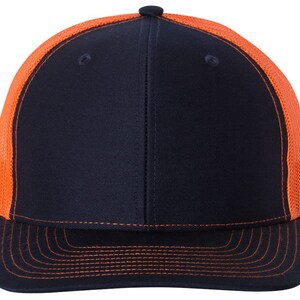 May include: A black and orange trucker hat with a mesh back. The hat has a curved brim and a flat crown.