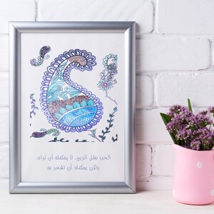 Op de afbeelding: Een ingelijst drukwerk met een blauw en paars paisley-ontwerp en Arabische tekst die luidt: "De liefde die in het hart is, ongeacht hoe verborgen, zal bekend worden door haar daden".