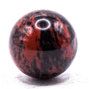 Può includere: Una gemma sferica lucidata con un sorprendente motivo di vortici rosso scuro e neri. La pietra a forma di sfera ha una finitura lucida, che riflette la luce. Questa pietra decorativa è ideale per collezionisti o come elemento d'arredo unico.