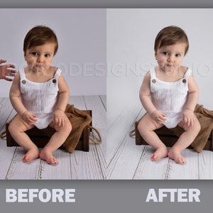 May include: A baby sitting in a wooden crate with a brown blanket. The baby is wearing a white onesie with buttons. The baby is looking at the camera.