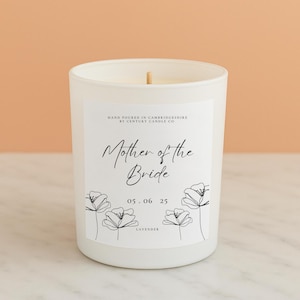 May include: White candle with a label that says "Mother of the Bride" and "05.06.25" with a floral design. The candle is labelled "Lavender".