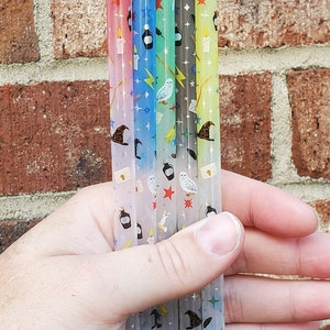 May include: Six clear plastic straws with a colorful gradient and a repeating pattern of stars, owls, wands, and potion bottles.