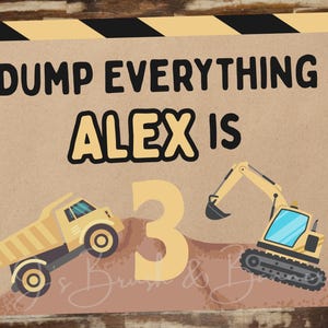 May include: A rectangular sign with the text "DUMP EVERYTHING ALEX IS 3". The sign features illustrations of a dump truck and an excavator in yellow and black, set against a brown background. The sign has black and yellow diagonal stripes.