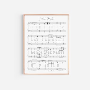 May include: A framed print of the sheet music for "Silent Night", with black notes on a white background. The title is in cursive script. The print is in a thin, gold-coloured frame, ideal for home decoration.