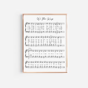 May include: A framed print displaying sheet music with the title "We Three Kings" in stylish script. The musical notes and lyrics are printed in black on a white background, within a thin gold frame. A classic piece of wall art.