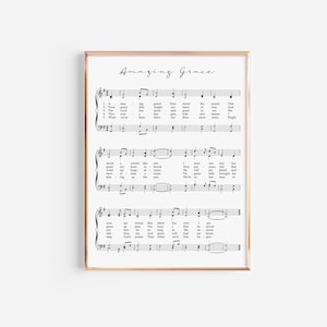 May include: A printable sheet music poster with the lyrics and musical notes for the hymn "Amazing Grace". The poster is printed on white paper and framed in a gold frame.