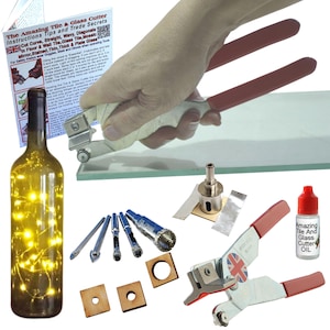 May include: A set of tools for cutting glass and tile, including a glass cutter, a drill bit set, a bottle cutter, and a bottle of oil. The tools are arranged on a white background. The glass cutter has red handles and a silver blade. The drill bits are various sizes and are made of metal. The bottle cutter is a small, handheld device with a silver blade. The bottle of oil is clear and has a red label that says "Amazing Tile And Glass Cutter Oil".