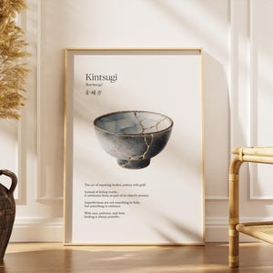 Könnte beinhalten: Ein gerahmter Druck mit einer Kintsugi-Schale, einer japanischen Kunstform zur Reparatur zerbrochener Keramik mit Gold. Die Schale ist grau und blau mit goldenen Akzenten. Der Druck enthält das Wort "Kintsugi" und eine Beschreibung.
