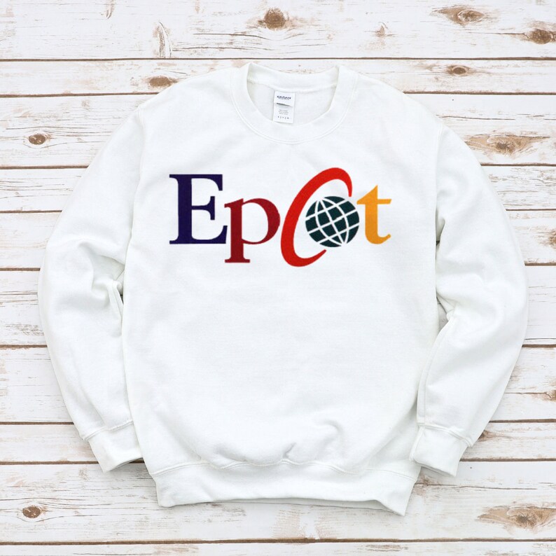 May include: White sweatshirt with a colorful "Epcot" logo featuring a globe and a red arc.