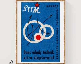 May include: A rectangular poster with a blue background featuring the text STTM, a red star, and black arrows intersecting white circular outlines. A solid red circle is inside the larger white circle. The text reads Dnes mladý technik zítra zlepšovatel.