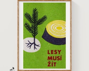 May include: A framed print on a green background featuring a black graphic of a small conifer tree with roots and a yellow and black tree stump. The text LESY MUSÍ ŽÍT is printed in red in the lower right corner of the artwork.