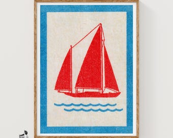 May include: A rectangular print featuring a centered red sailboat with two sails on a cream background, framed by a thick blue border. Below the boat are three stylized blue wavy lines representing water, all enclosed in a wooden frame.