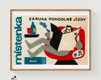 May include: A framed vintage-style print featuring a stylized illustration of a person reading a newspaper in a red chair. The text reads Místenka and ZÁRUKA POHODLNÉ JÍZDY. The design uses a palette of red, blue, black, and cream with a textured paper effect.