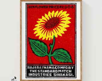 May include: A rectangular print featuring a bright yellow sunflower with green leaves centered on a vibrant red background. The text reads SUNFLOWER PRICE RE. 0-0-6 at the top and RAJARATNAM & COMFOBY THE STANDARD MATCH INDUSTRIES SIVAKASI at the bottom.
