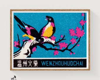 May include: A rectangular print featuring two birds perched on a black branch against a bright blue background. The birds have black, yellow, and pink plumage. Pink blossoms adorn the branch. The text WENZHOUHUOCHAI is printed at the bottom.