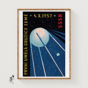May include: A rectangular print featuring a stylized illustration of the Sputnik satellite against a dark blue space background. The text reads 4. X. 1957, SSSR, and PRVNÍ UMĚLÁ DRUŽICE ZEMĚ. The satellite has a spherical body with four long antennas.