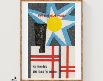 May include: A framed vintage advertisement poster featuring a blue star, a yellow circle, and a black silhouette. The text reads MYTÍ NENÍ VELKÉ PRÁDLO and NA POKOŽKU JEN TOALETNÍ MÝDLO. The design includes white rectangular blocks with red grid lines.